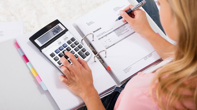 Woman using calculator to calculate HOA finances